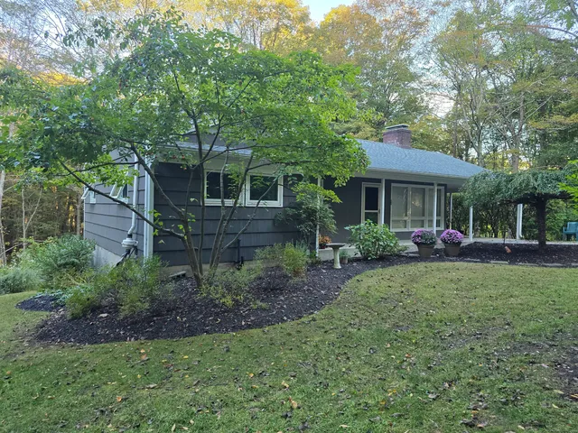 a view of a house with backyard sitting area and garden