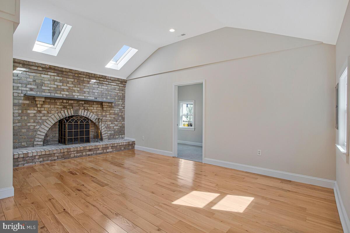 1916 Ridgeville Road Edgewater, MD 21037 - Photo 9 of 27 an empty room with wooden floor and fireplace
