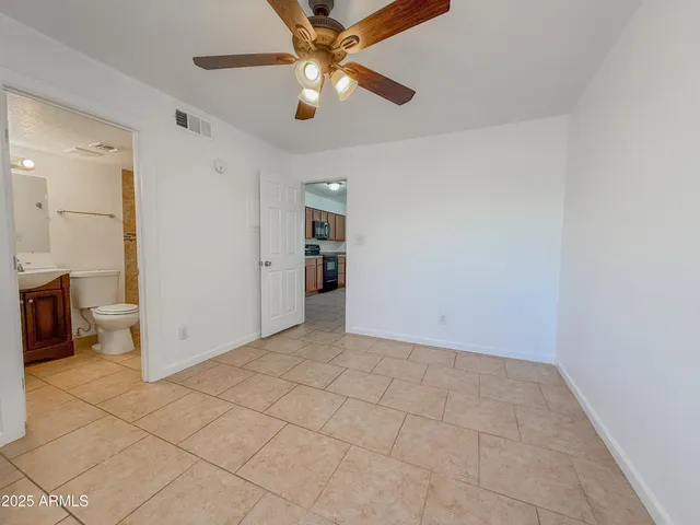 an empty room with closet and fan