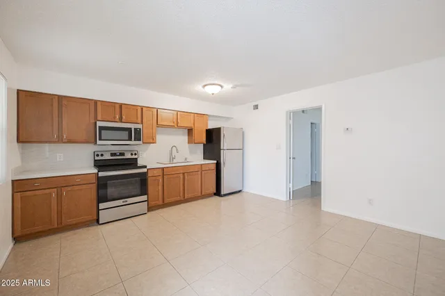 a kitchen with stainless steel appliances granite countertop a stove refrigerator and a microwave oven