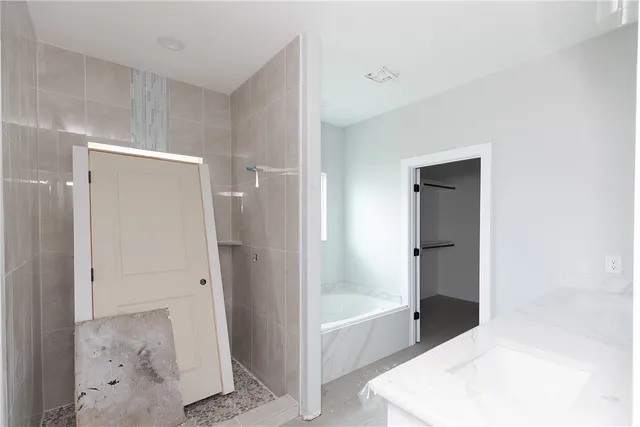 a bathroom with a tub shower and closet
