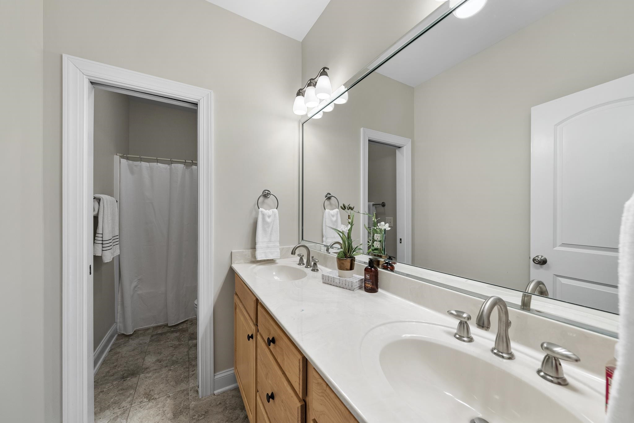 7357 Newport Avenue Raleigh, NC 27613 - Photo 24 of 44 a bathroom with a double vanity sink a mirror and a