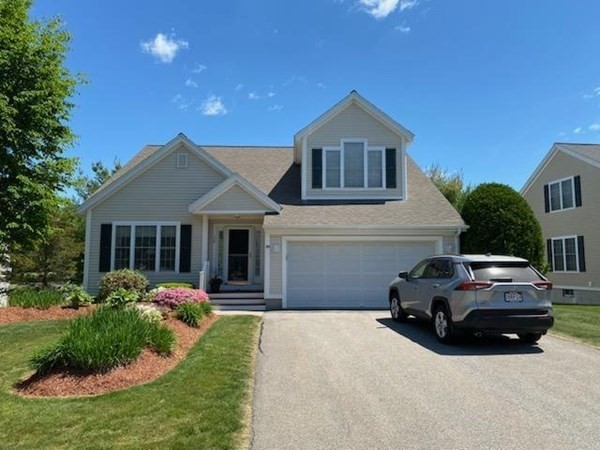 a front view of a house with a garden and yard