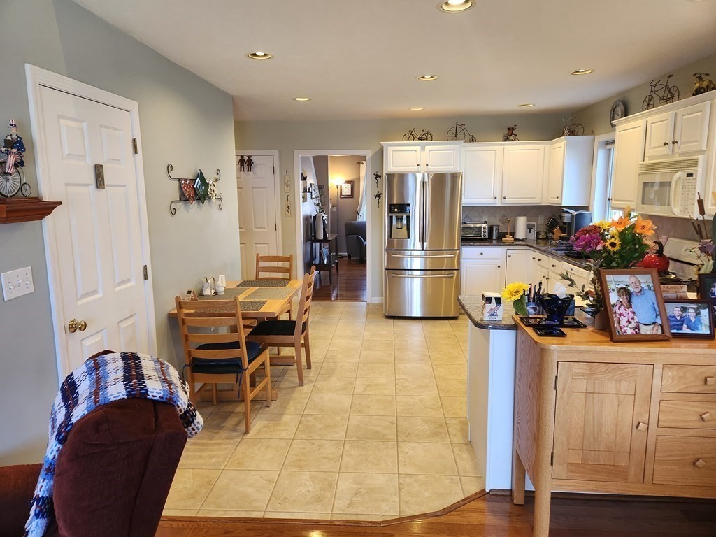 20 Augusta Way, Unit 20 Chelmsford, MA 01863 - Photo 7 of 11 a living room with furniture a dining table and a refrigerator