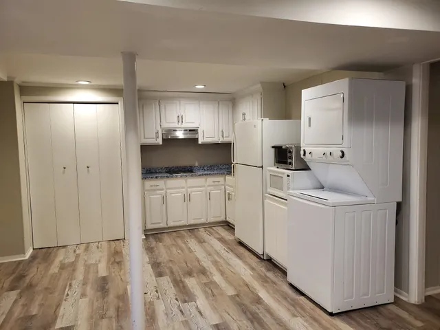 a kitchen with white cabinets and white appliances