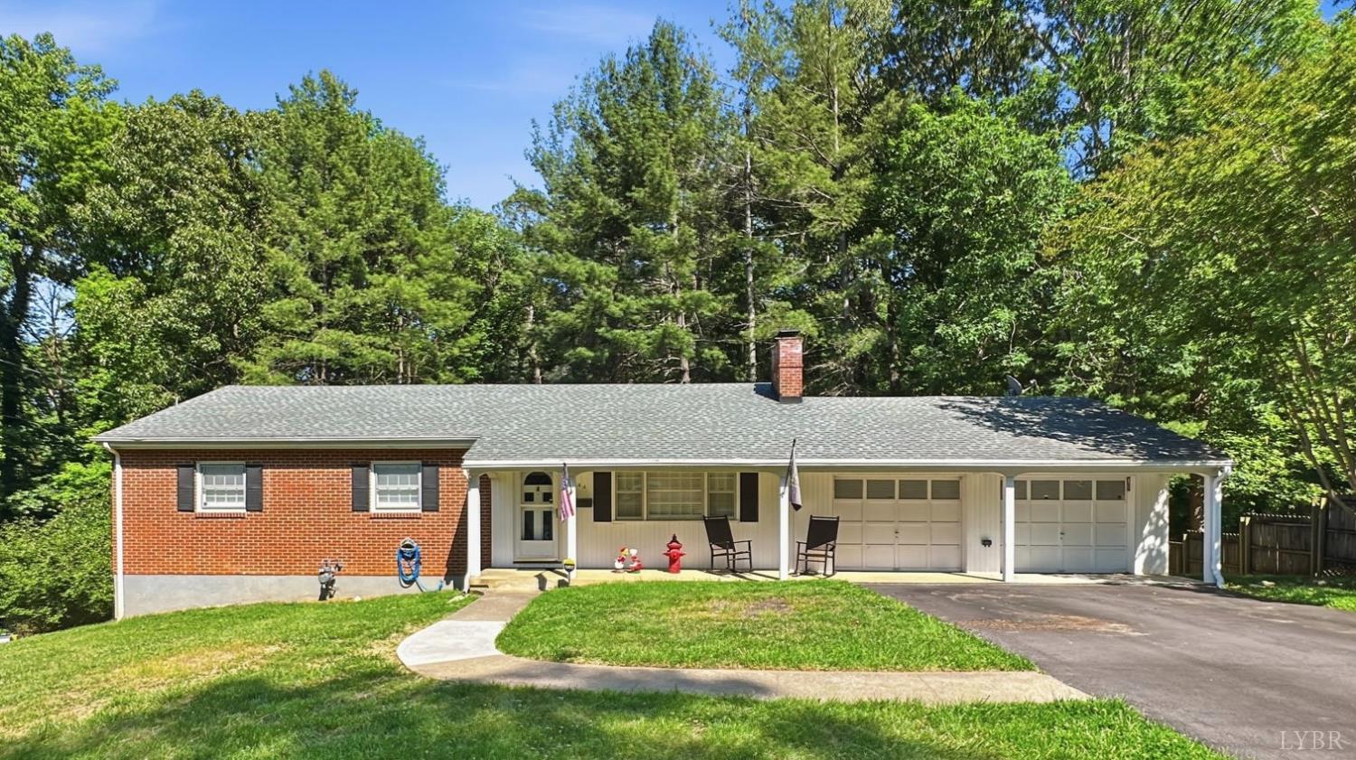 a front view of a house with a yard and trees