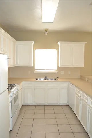 a kitchen with a sink a stove and cabinets