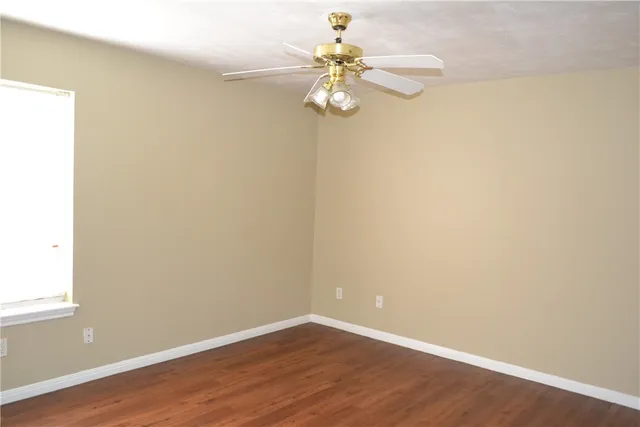 an empty room with wooden floor and window
