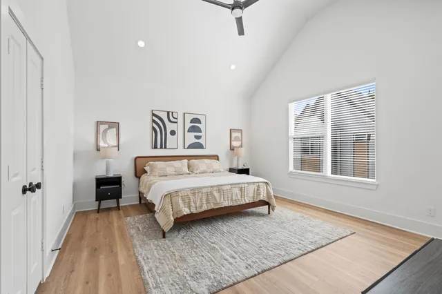 a spacious bedroom with a large bed rug and a window