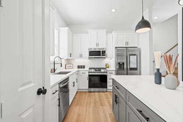 a kitchen with stainless steel appliances granite countertop a sink refrigerator and cabinets