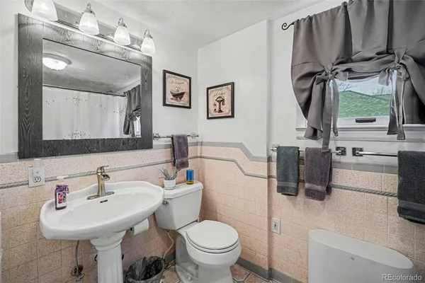 a bathroom with a sink toilet and a mirror