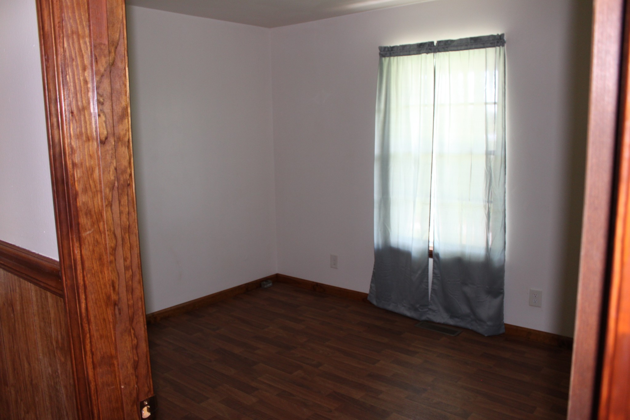 6923 Old Mill Hill Road Dowelltown, TN 37059 - Photo 24 of 43 an empty room with wooden floor and windows with curtains