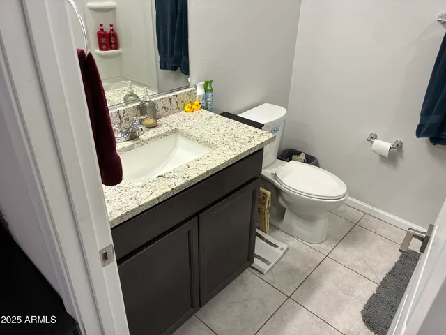 a bathroom with a granite countertop sink a toilet and a mirror