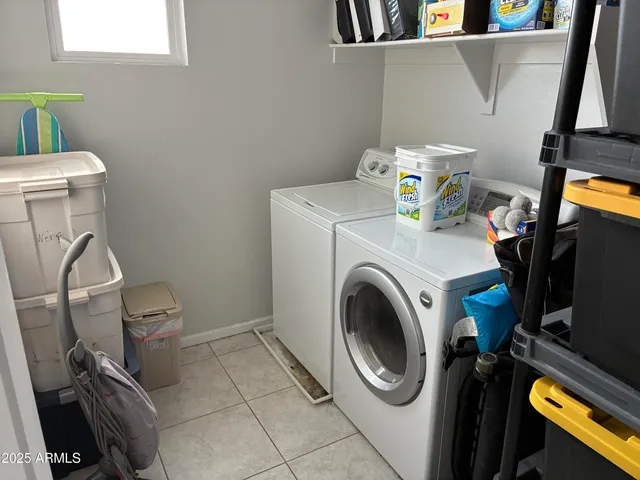 a utility room with dryer washer and a view of storage