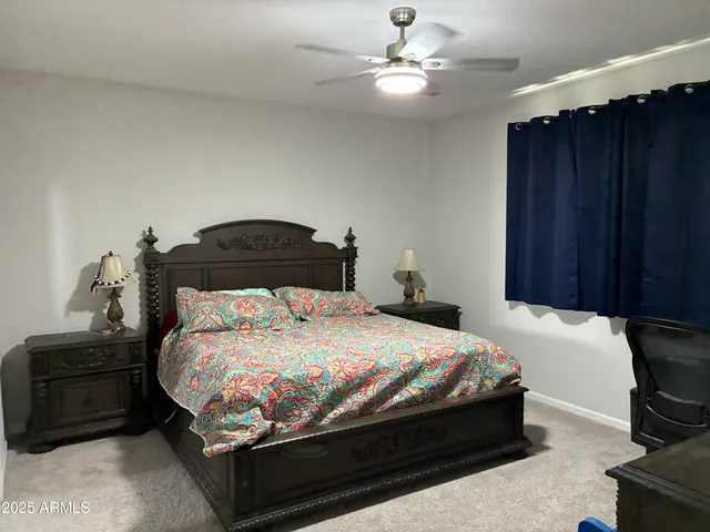 a bedroom with a bed and a ceiling fan