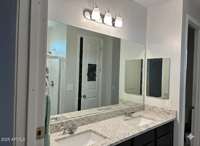 a bathroom with a granite countertop sink and a mirror