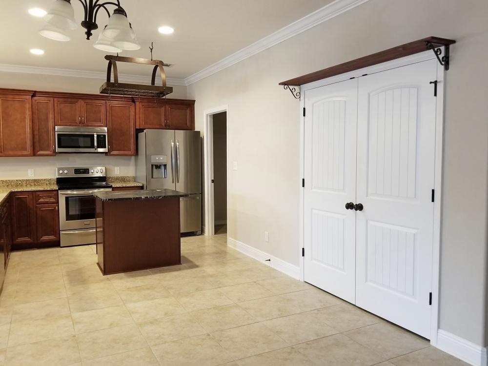 5618 Price Plantation Road Baker, FL 32531 - Photo 8 of 24 a kitchen with stainless steel appliances granite countertop a stove top oven a sink and a refrigerator