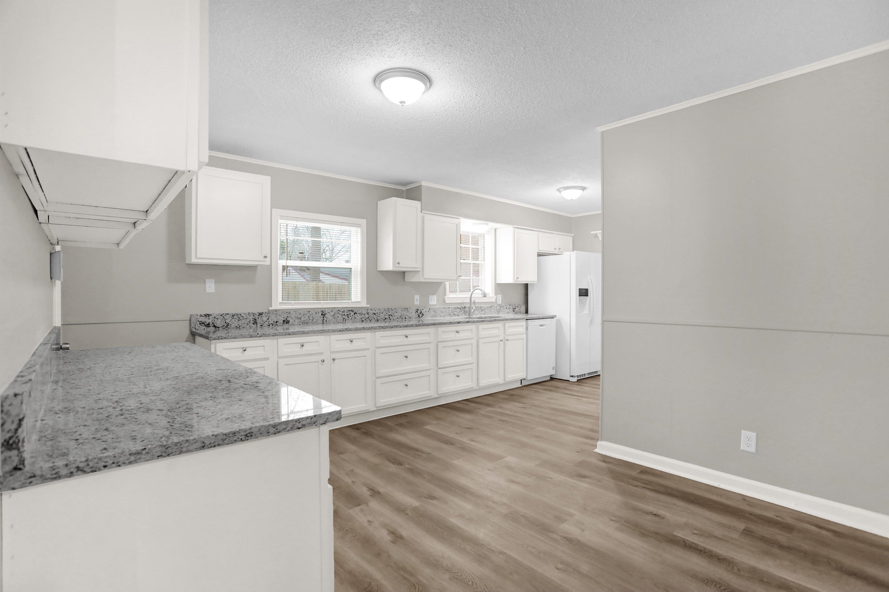 2853 Clearbrook Street Memphis, TN 38118 - Photo 11 of 30 Kitchen featuring white appliances, white cabinets, a sink, and light wood-style flooring