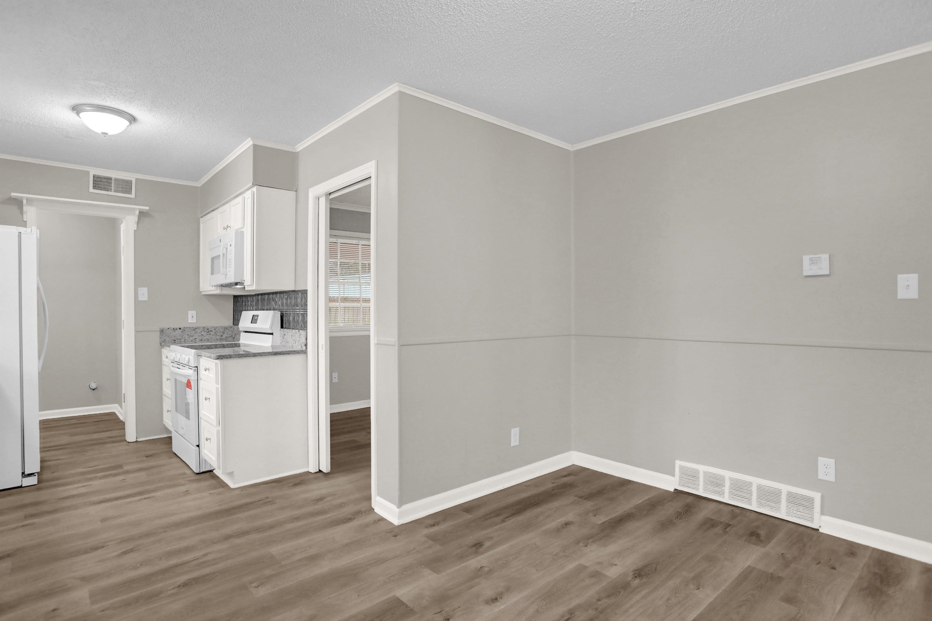 2853 Clearbrook Street Memphis, TN 38118 - Photo 12 of 30 Kitchen featuring white appliances, visible vents, white cabinets, and wood finished floors