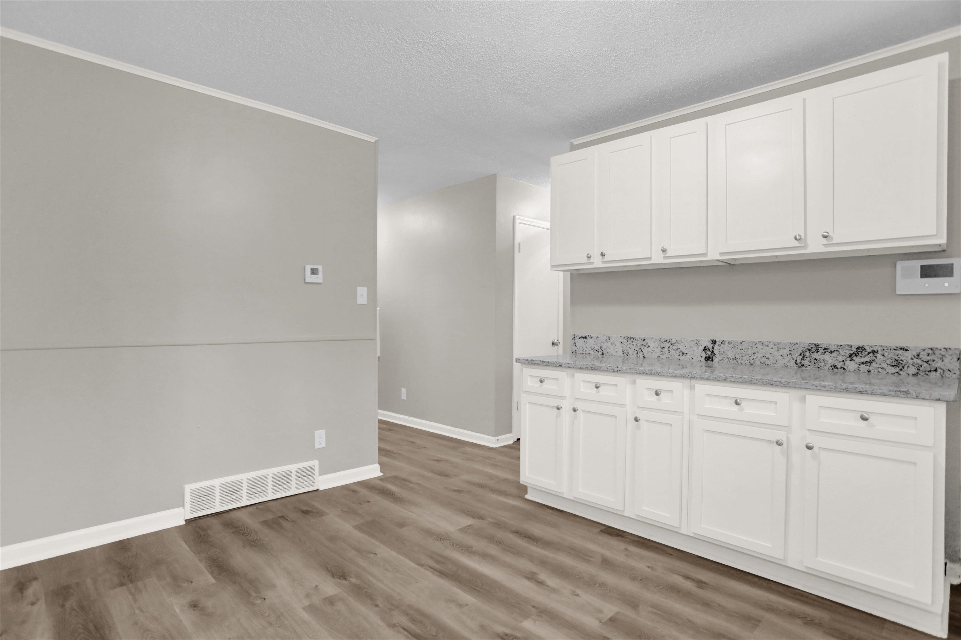 2853 Clearbrook Street Memphis, TN 38118 - Photo 14 of 30 Kitchen featuring light wood finished floors, visible vents, white cabinets, a textured ceiling, and baseboards
