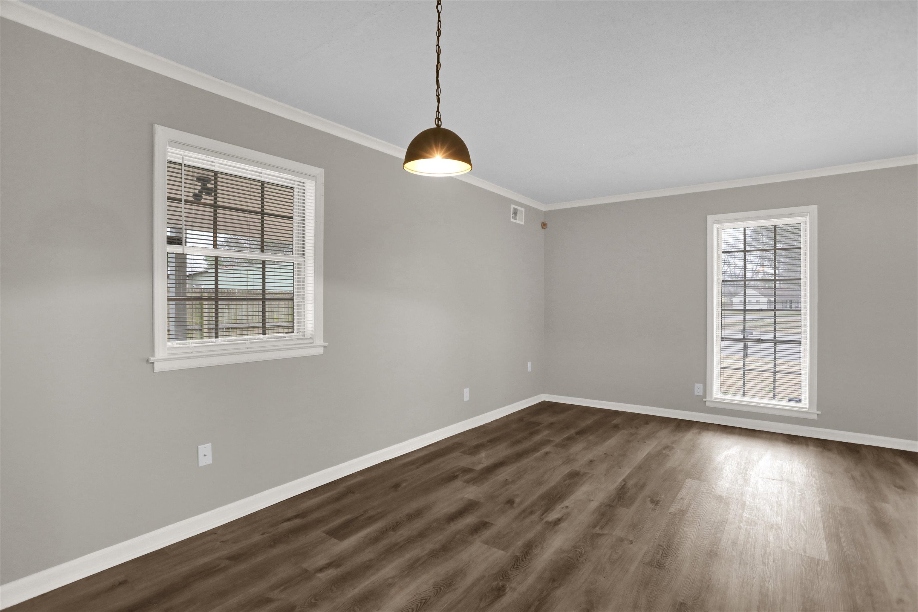 2853 Clearbrook Street Memphis, TN 38118 - Photo 7 of 30 Spare room featuring baseboards, dark wood-style flooring, visible vents, and crown molding