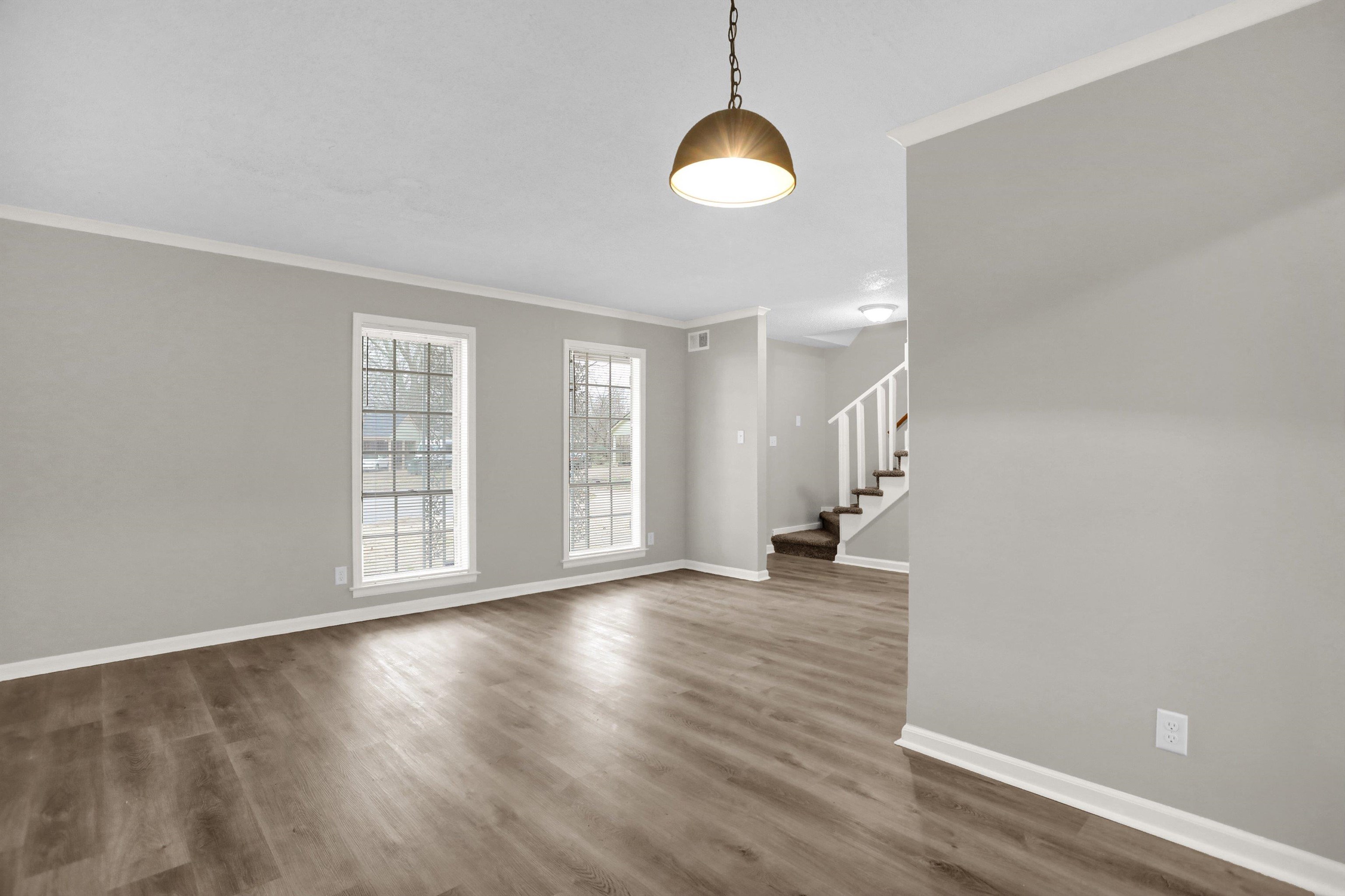 2853 Clearbrook Street Memphis, TN 38118 - Photo 9 of 30 Interior space featuring dark wood-type flooring, visible vents, baseboards, ornamental molding, and stairway