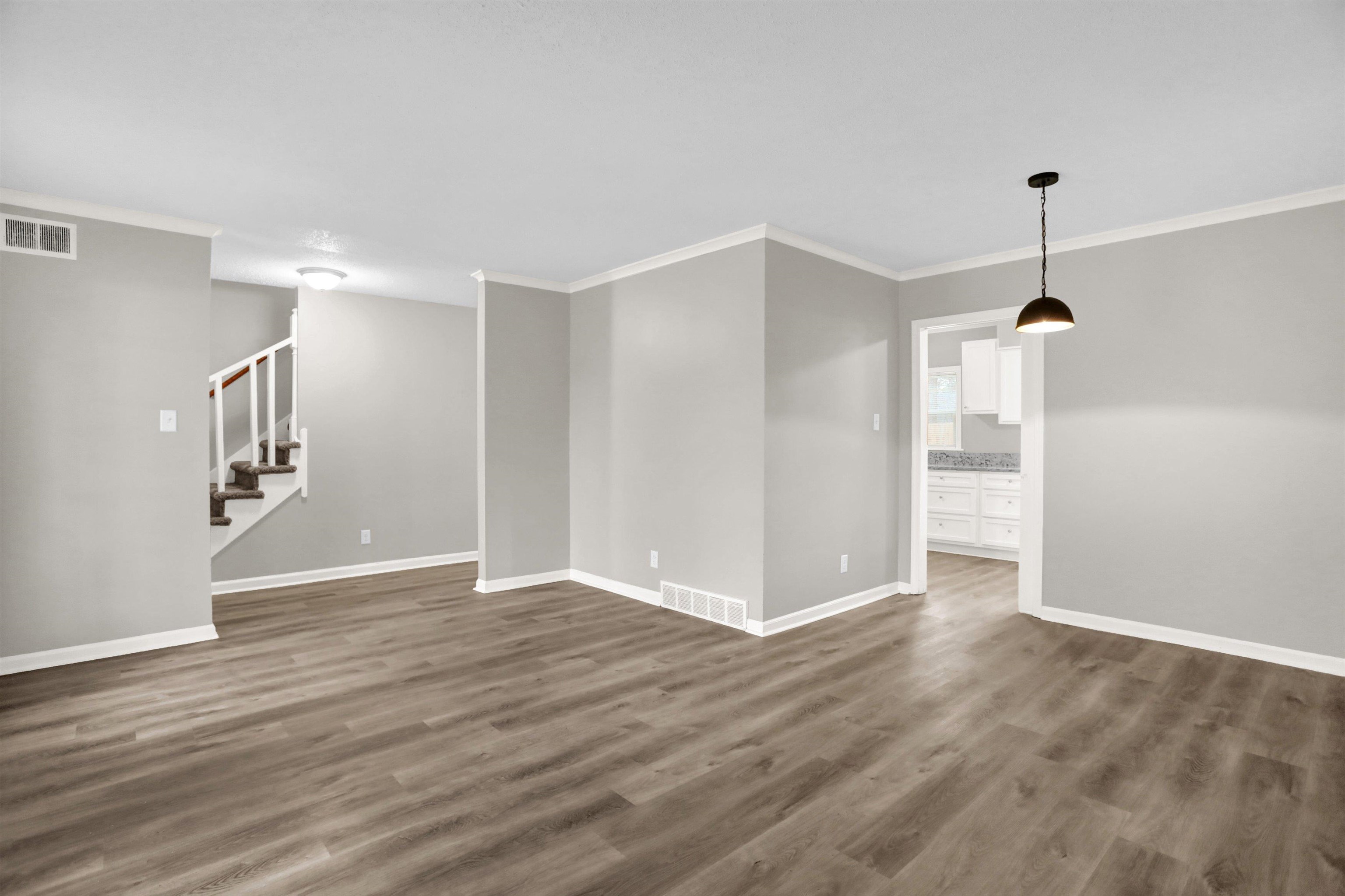 2853 Clearbrook Street Memphis, TN 38118 - Photo 10 of 30 Empty room featuring dark wood-type flooring, visible vents, and stairway