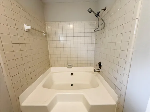 a bathroom with a white bath tub and a shower