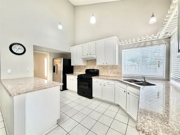 a kitchen with granite countertop white cabinets and white appliances