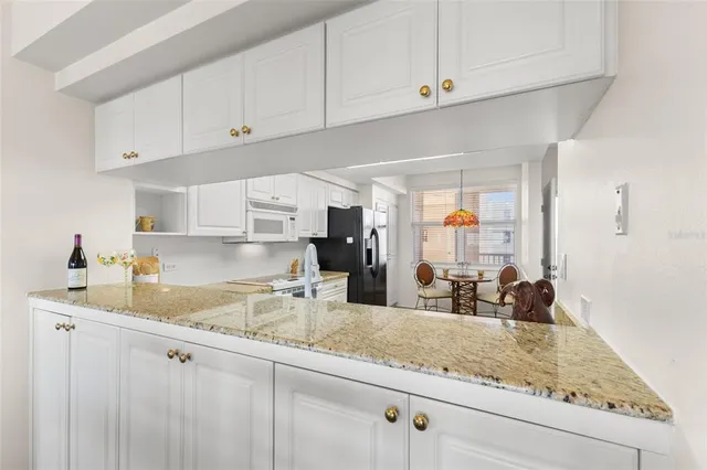 a kitchen with stainless steel appliances granite countertop a stove oven and a refrigerator