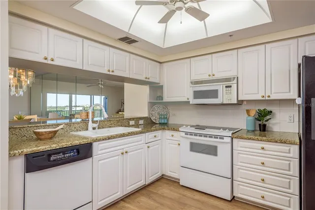 a kitchen with granite countertop a sink appliances cabinets and counter space