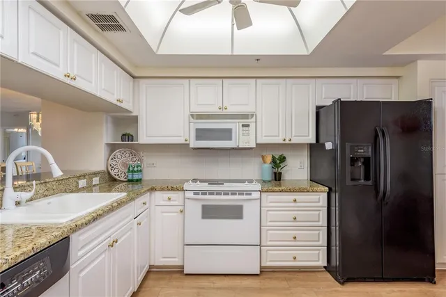 a kitchen with stainless steel appliances kitchen island a refrigerator and a table