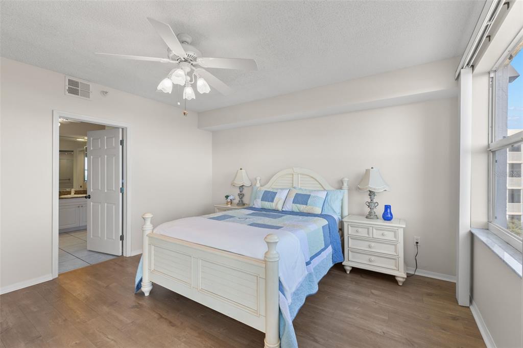 6475 Shoreline Drive, Unit 5403 St. Petersburg, FL 33708 - Photo 24 of 46 a bedroom with a bed and a chandelier