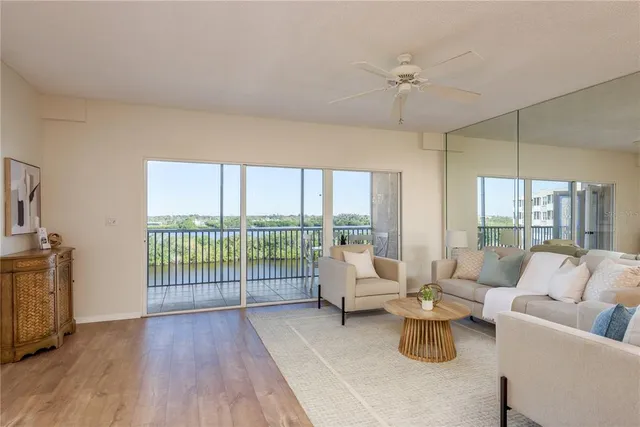 a living room with furniture and a large window with balcony view