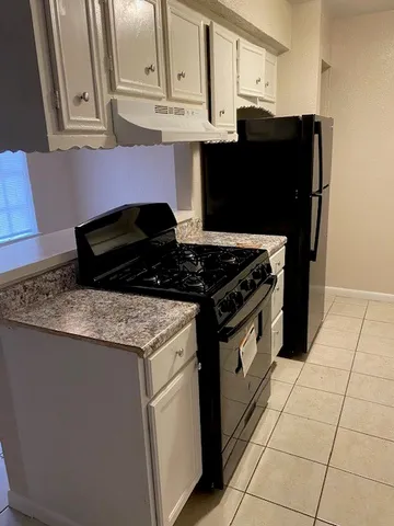 a kitchen with granite countertop a stove and a cabinets
