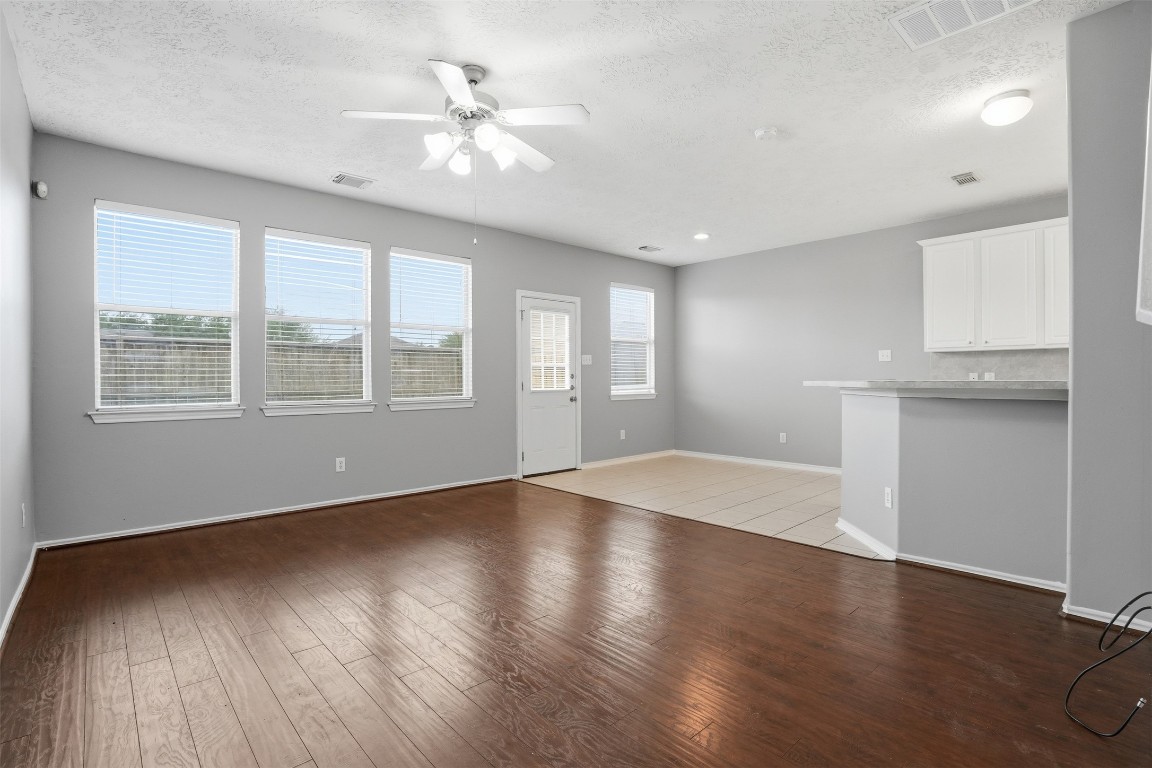 13084 Peppergate Lane Houston, TX 77044 - Photo 3 of 10 a view of an empty room with a window and wooden floor