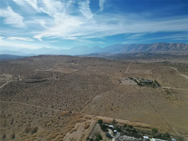 a view of a dry yard with wooden fence