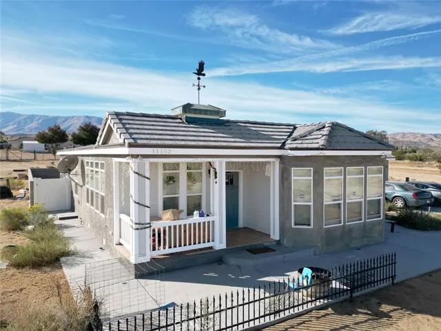 a view of a house with a balcony and wooden deck