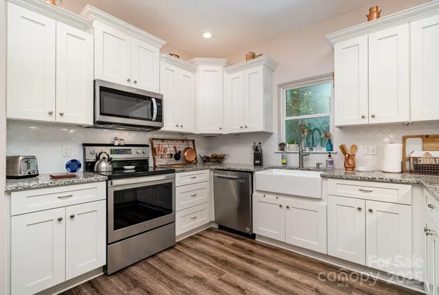 a kitchen with cabinets stainless steel appliances a sink and a window