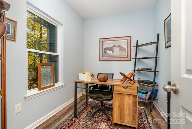 a view of a workspace with furniture and a window