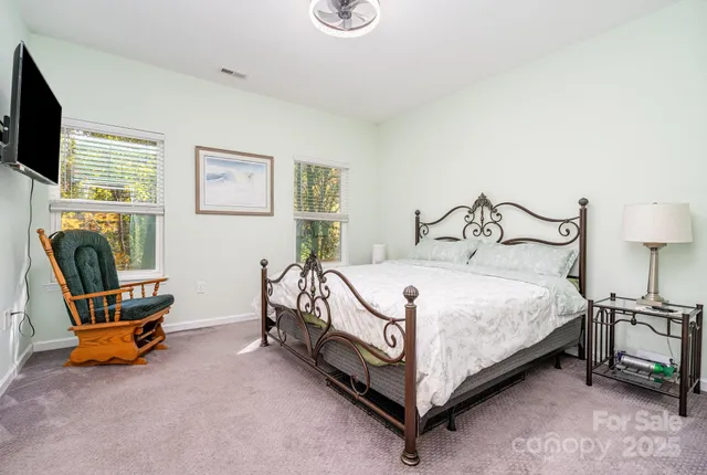 a bedroom with bed and a flat screen tv