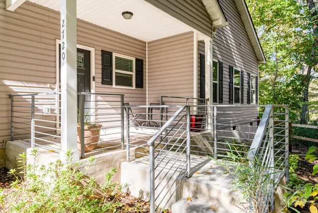 a view of a house with a wooden deck and a floor to ceiling window