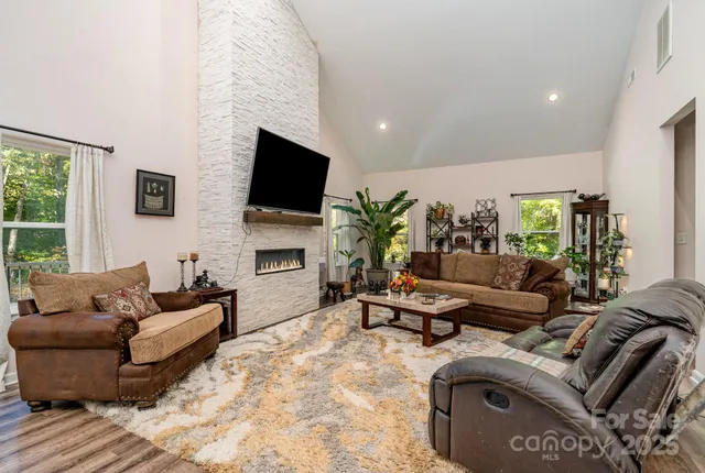 a living room with furniture a flat screen tv and a fireplace