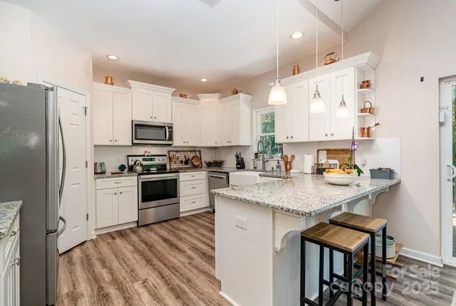 a kitchen with stainless steel appliances granite countertop a stove refrigerator sink and cabinets