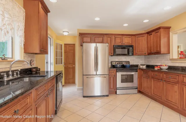 a kitchen with stainless steel appliances granite countertop a refrigerator sink and stove