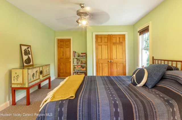 a bedroom with a bed a dresser with wooden floor