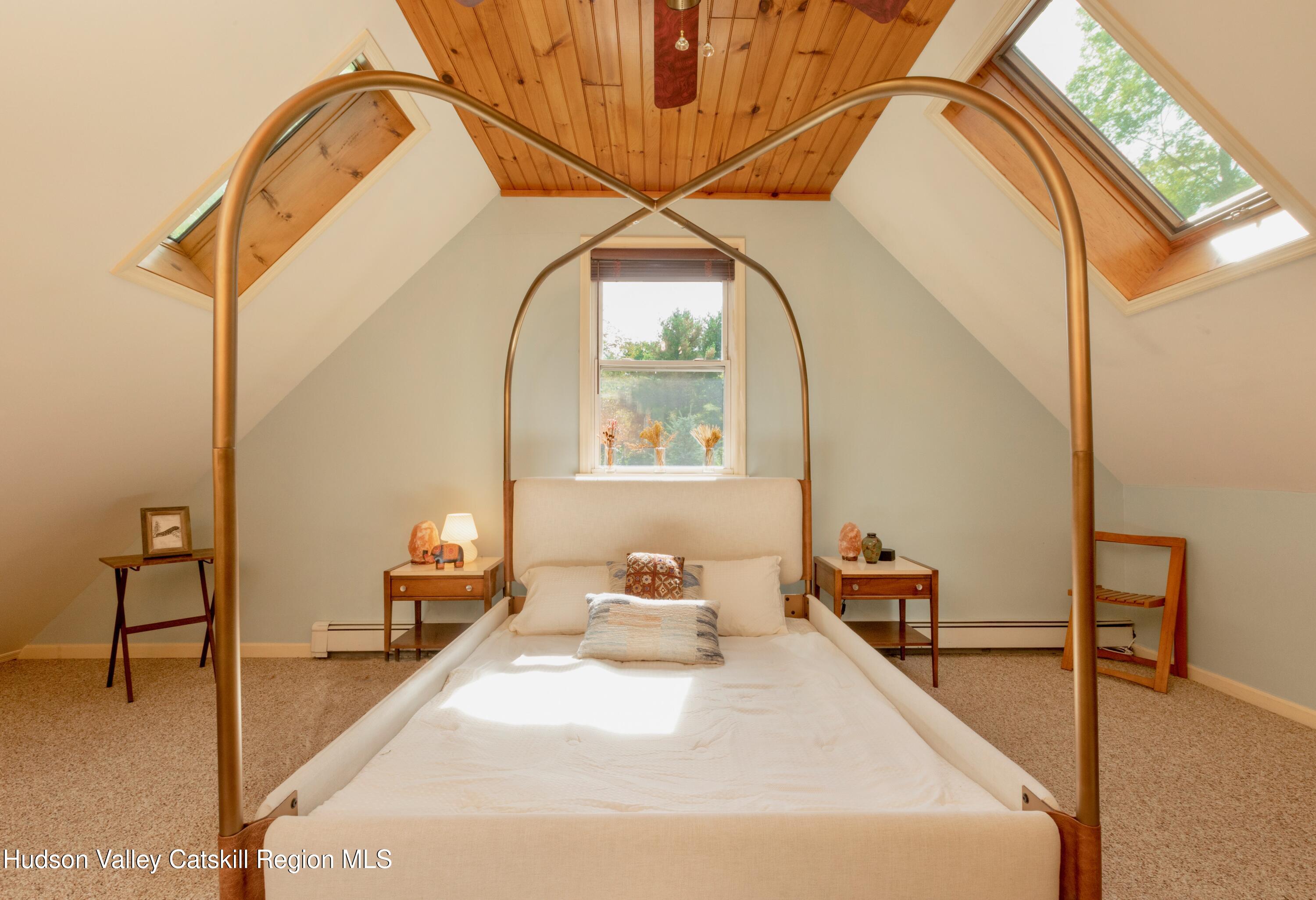 688 Churchland Road Saugerties, NY 12477 - Photo 19 of 37 a bedroom with a bed and a chandelier