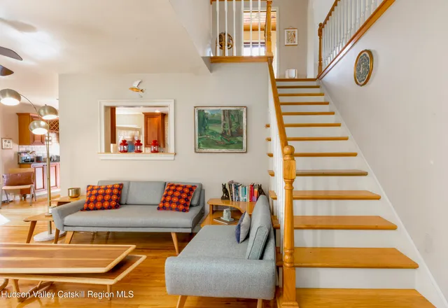 a living room with furniture and a white wall with wooden floor