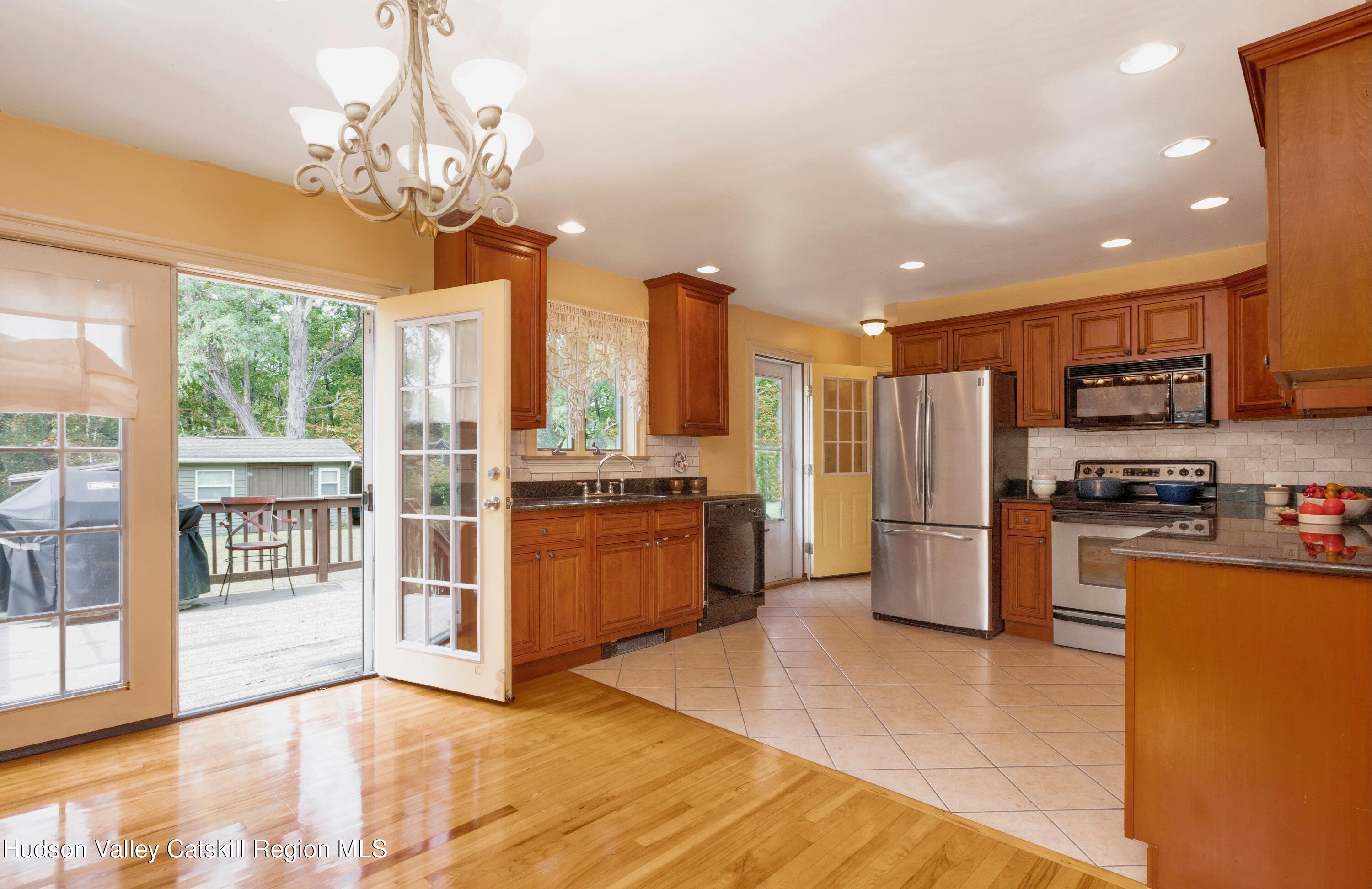 688 Churchland Road Saugerties, NY 12477 - Photo 8 of 37 a view of kitchen with stainless steel appliances granite countertop a refrigerator a stove top oven and a sink with wooden floor