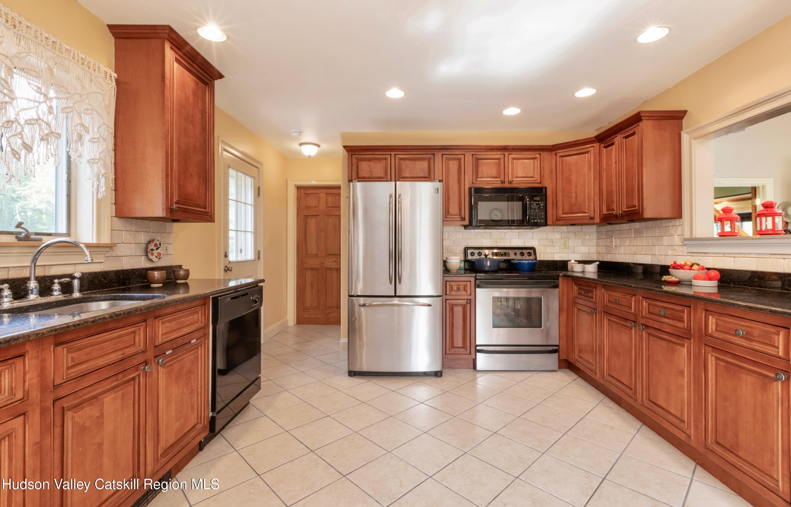 688 Churchland Road Saugerties, NY 12477 - Photo 10 of 37 a kitchen with stainless steel appliances granite countertop a stove top oven a sink and a refrigerator